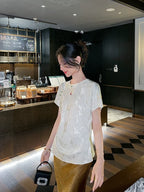Close-up of an ivory silk blend jacquard blouse with a relaxed fit and subtle woven texture.