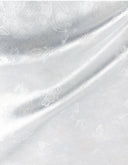 Draped ivory jacquard fabric showing its sheen and delicate woven pattern.