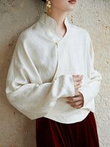 Close-up of the ivory Mandarin collar wrap blouse showing the crossover neckline and fabric texture.