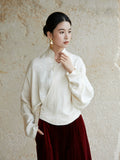 Side view of an ivory wrap blouse featuring a Mandarin collar and relaxed fit.