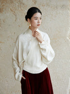 Side view of an ivory wrap blouse featuring a Mandarin collar and relaxed fit.