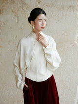 Side view of an ivory wrap blouse featuring a Mandarin collar and relaxed fit.