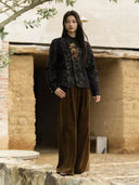Charcoal black floral jacquard jacket paired with brown wide-leg trousers, showing its short silhouette and long sleeves