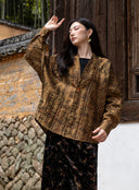 Model wearing the buttoned Mingcha Brown jacket with one arm raised.