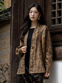 Three-quarter view of the model wearing the loose plaid jacket over a black top.