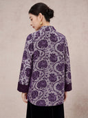Back view of the model wearing the all-over purple floral jacket