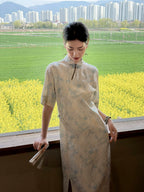 Woman wearing a light blue mandarin collar dress overlooking a spring countryside landscape
