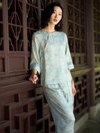 Woman wearing a light blue jacquard silk blouse styled with matching wide-leg pants