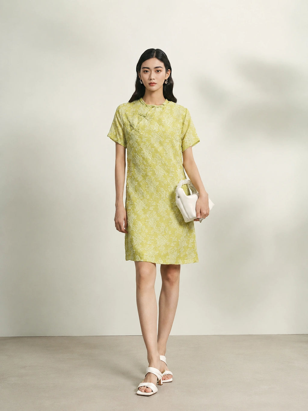 Model wearing a light green floral mulberry silk shift dress with short sleeves and relaxed fit.