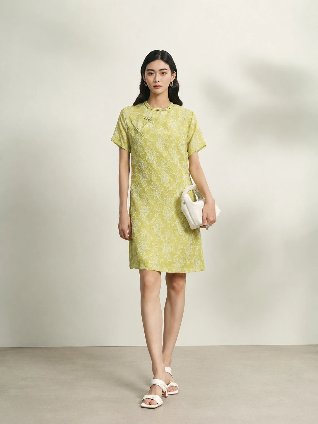 Model wearing a light green floral mulberry silk shift dress with short sleeves and relaxed fit.