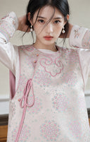Portrait highlighting the vest’s pastel floral jacquard and pink wrap-front details.