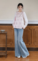 Model wearing the pink wrap-front vest with a white inner top and wide-leg jeans.