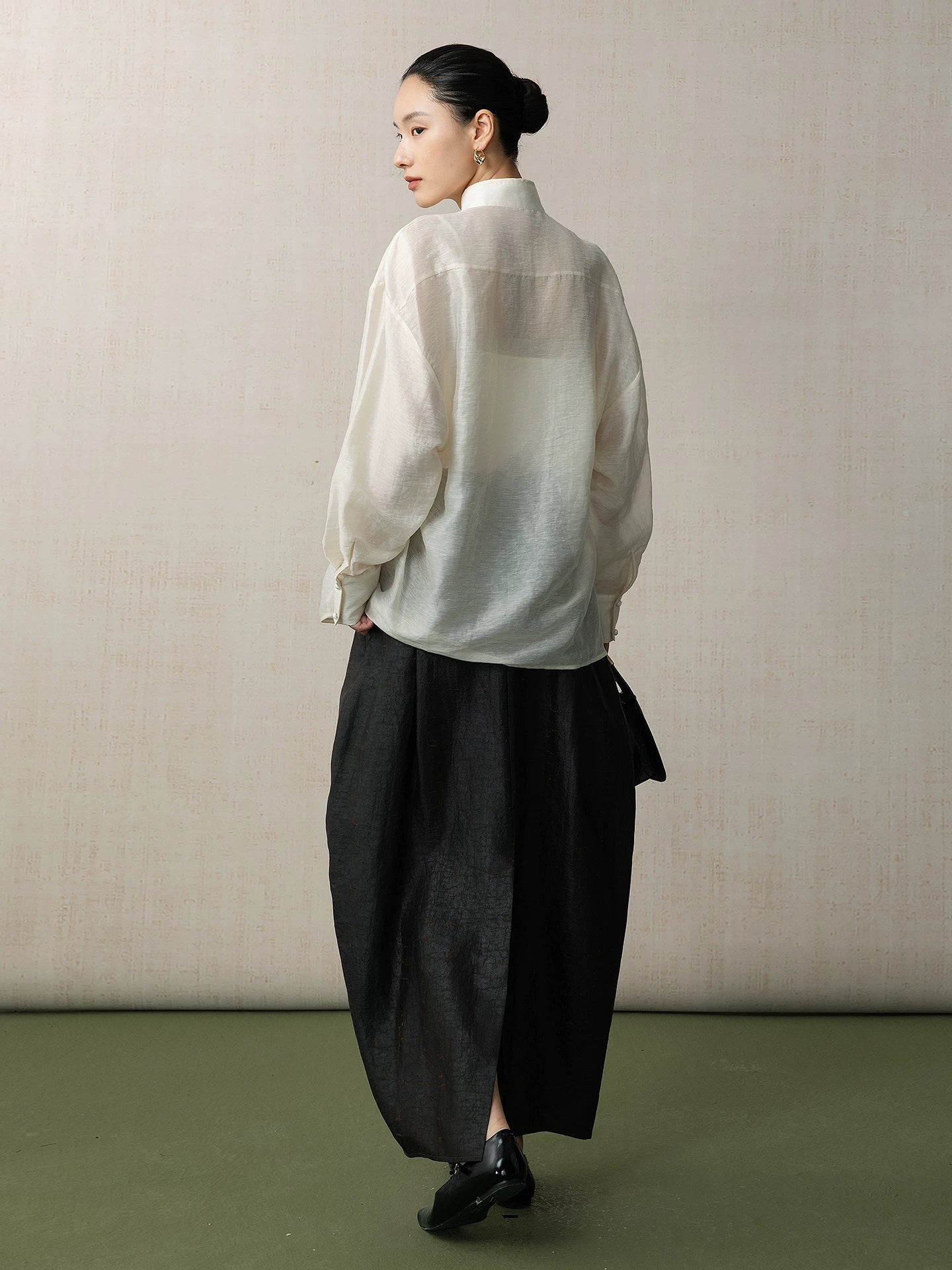 Back view of a women's lyocell linen blend blouse with a loose fit and mandarin collar.