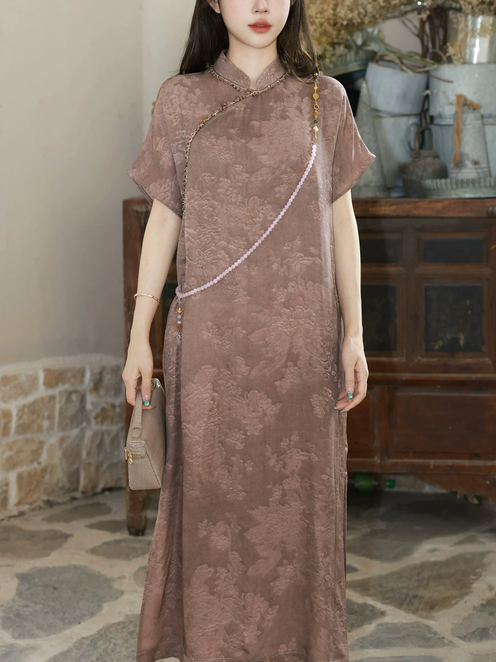 Close-up of the mauve silk-blend dress showing the stand collar and tone-on-tone floral texture