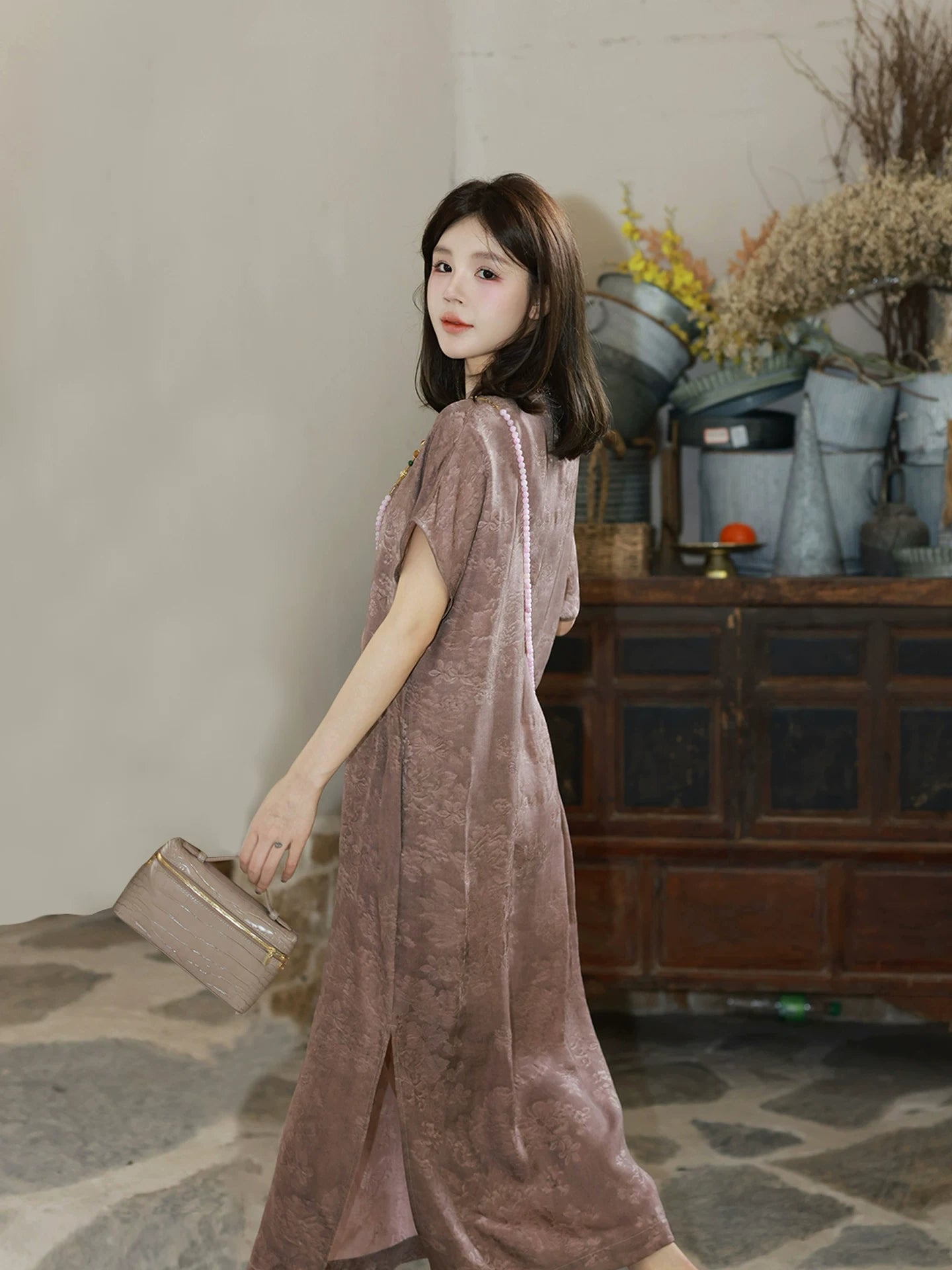 Side view of a mauve Chinese-inspired dress showing its relaxed silhouette and floral texture