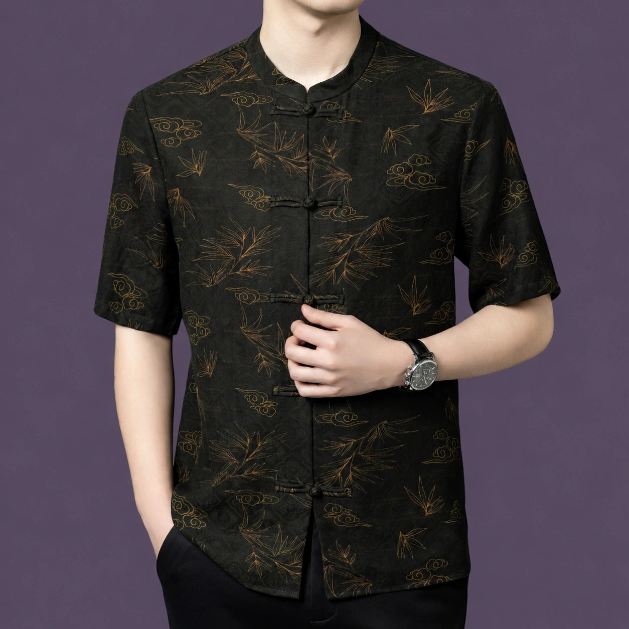 Close-up angle of the textured black silk top, highlighting the detailed bamboo leaf and auspicious cloud motifs woven into the fabric.
