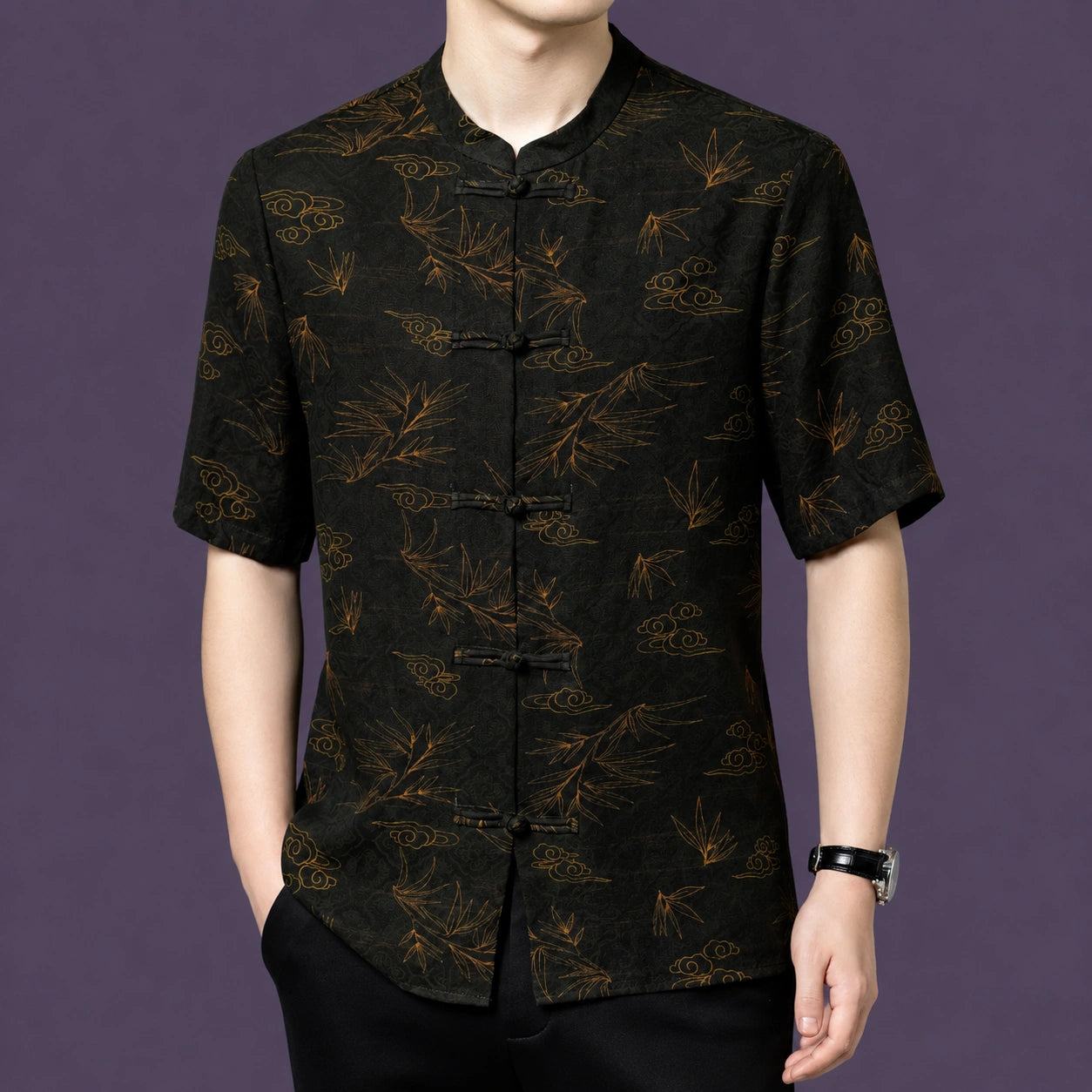 Men's black silk short-sleeve shirt with a stand collar and vintage-inspired traditional print, styled with black trousers and a watch.