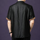 Back view of the black crackle silk shirt, showcasing the consistent texture and the brown contrast binding on the cuffs.