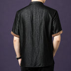 Back view of the black crackle silk shirt, showcasing the consistent texture and the brown contrast binding on the cuffs.