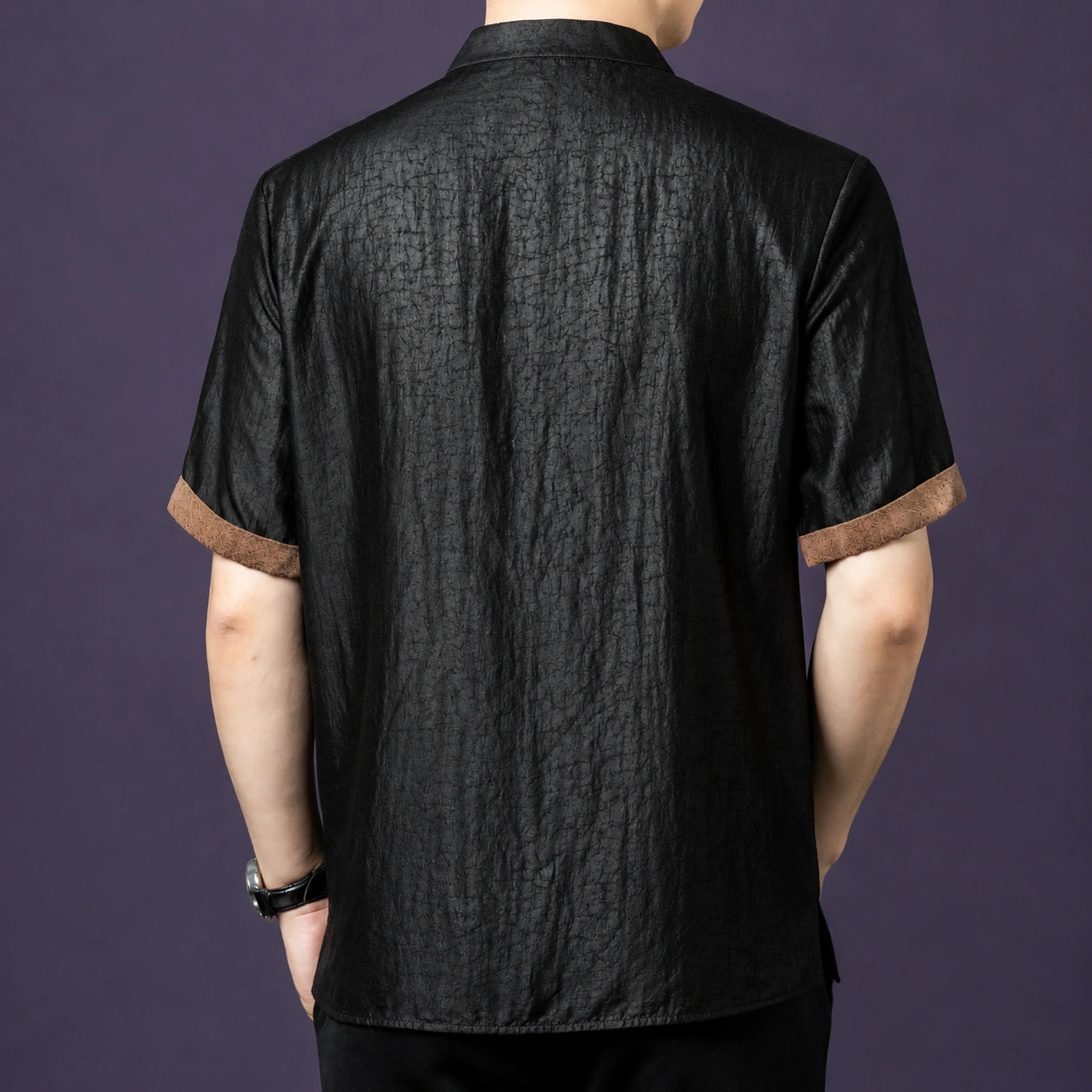 Back view of the black crackle silk shirt, showcasing the consistent texture and the brown contrast binding on the cuffs.