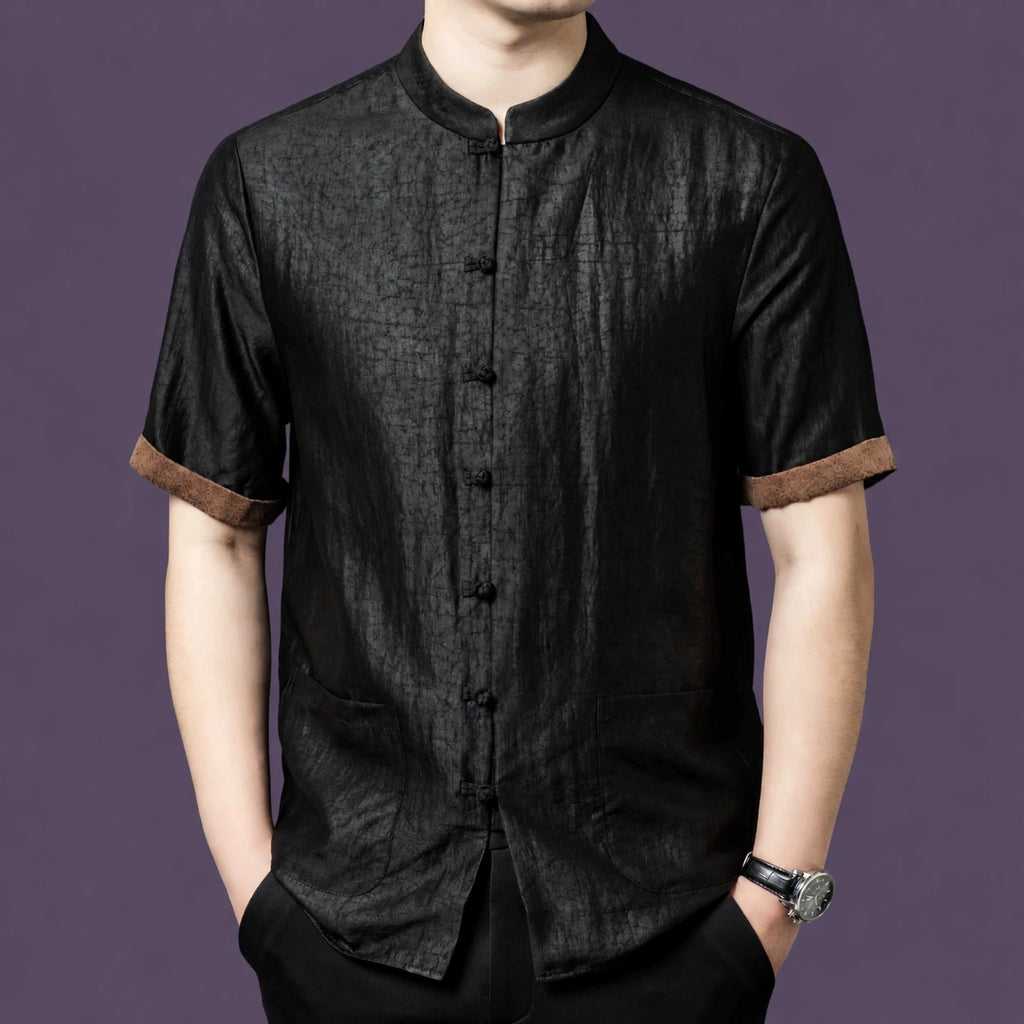 Men's black 100% mulberry silk short-sleeve shirt with a crackle texture, stand collar, front patch pockets, and contrasting brown cuffs.