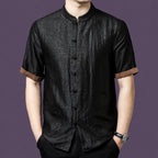 Men's black 100% mulberry silk short-sleeve shirt with a crackle texture, stand collar, front patch pockets, and contrasting brown cuffs.