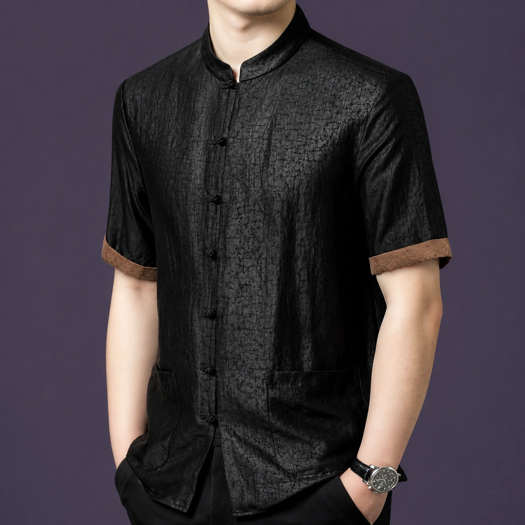 Front view of the black silk top, highlighting the traditional frog button placket and the earthy brown trim on the sleeves.