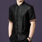 Front view of the black silk top, highlighting the traditional frog button placket and the earthy brown trim on the sleeves.