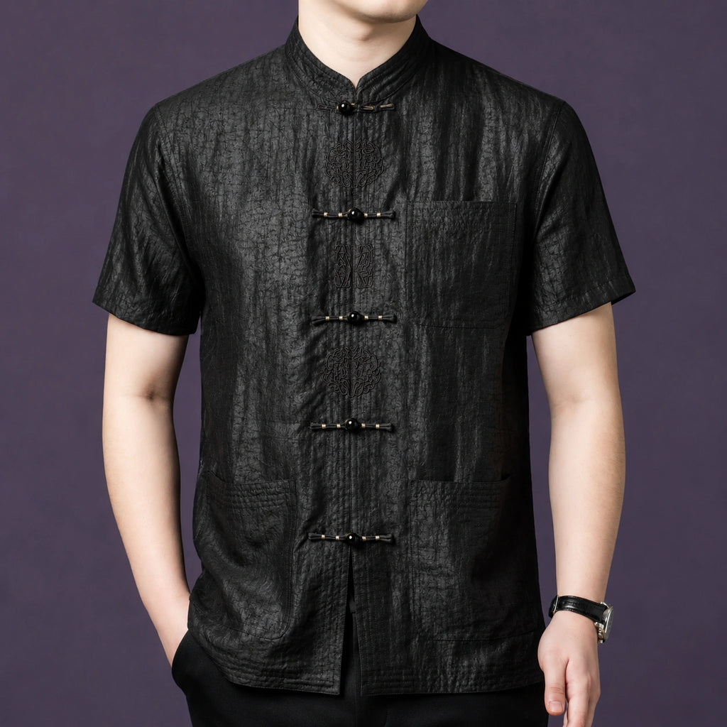 Men's black 100% mulberry silk short-sleeve shirt featuring a textured crackle finish, a stand collar, and delicate embroidered frog buttons down the front placket.