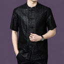 Close-up of the black silk shirt highlighting the unique cracked surface texture and the contrasting jacquard pattern along the front placket.