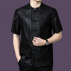 Close-up of the black silk shirt highlighting the unique cracked surface texture and the contrasting jacquard pattern along the front placket.