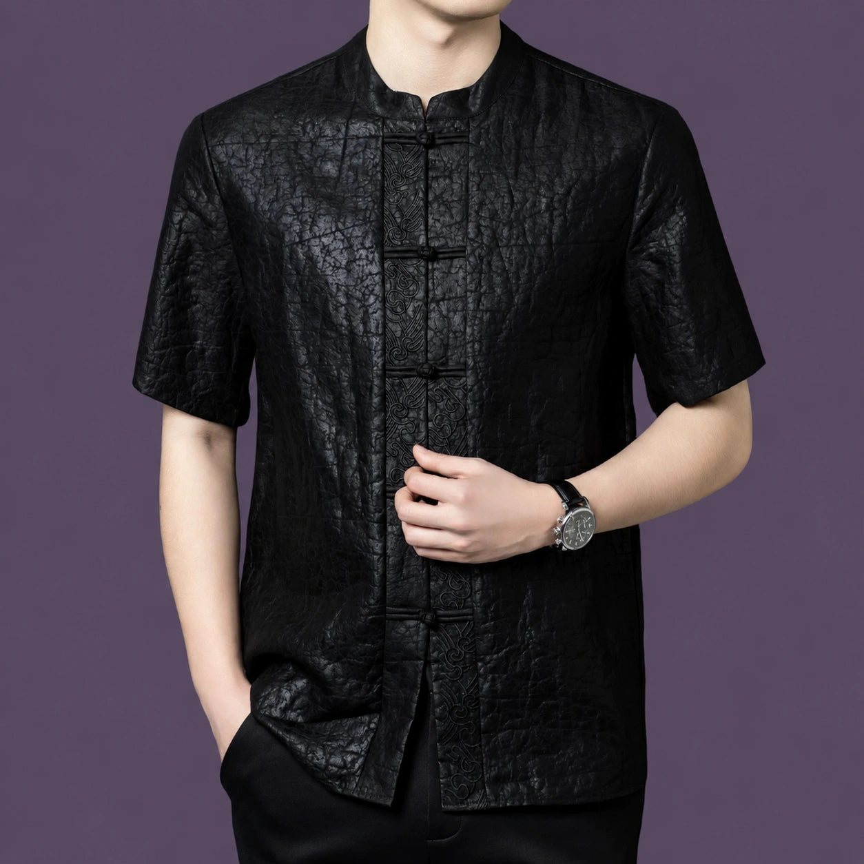 Close-up of the black silk shirt highlighting the unique cracked surface texture and the contrasting jacquard pattern along the front placket.