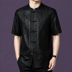 Men's black 100% mulberry silk short-sleeve shirt with a distinctive crackle leather-like texture, a stand collar, and traditional frog buttons.