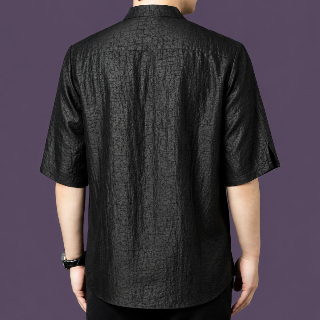 Back view of the black silk shirt, highlighting the consistent crackled texture across the back and the relaxed, straight silhouette.