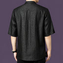 Back view of the black silk shirt, highlighting the consistent crackled texture across the back and the relaxed, straight silhouette.