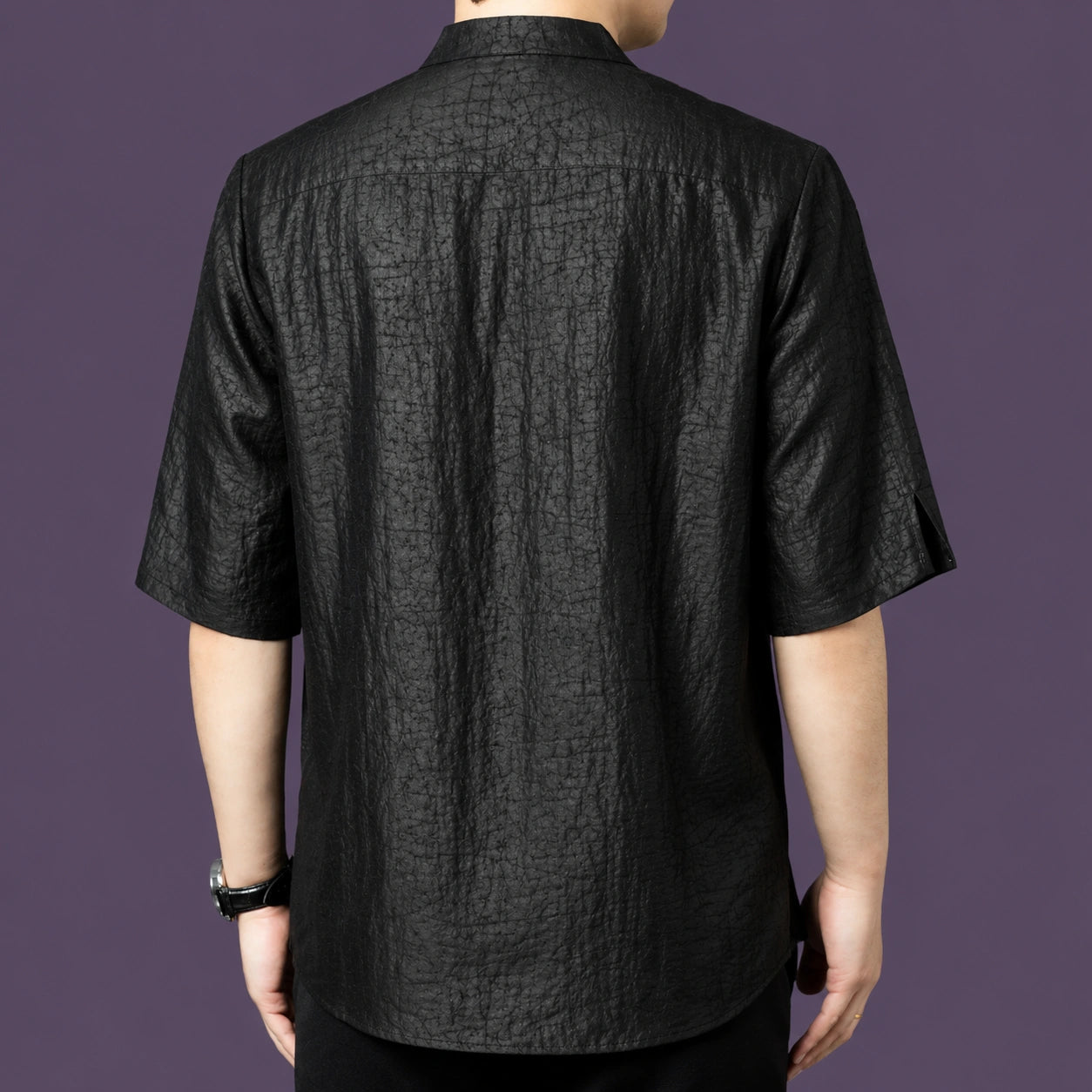 Back view of the black silk shirt, highlighting the consistent crackled texture across the back and the relaxed, straight silhouette.