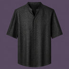 Flat lay of the men's black silk short-sleeve shirt, featuring a stand collar with a V-slit and a clean button-down front.