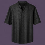 Flat lay of the men's black silk short-sleeve shirt, featuring a stand collar with a V-slit and a clean button-down front.