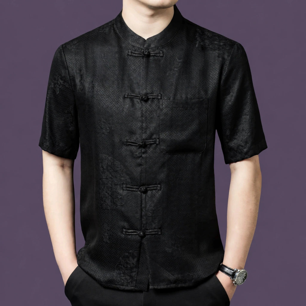 Men's black 100% mulberry silk short-sleeve shirt with a subtle jacquard pattern, a stand collar, traditional frog buttons, and a single chest pocket.