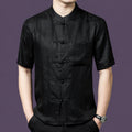 Men's black 100% mulberry silk short-sleeve shirt with a subtle jacquard pattern, a stand collar, traditional frog buttons, and a single chest pocket.
