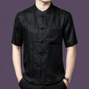 Men's black 100% mulberry silk short-sleeve shirt with a subtle jacquard pattern, a stand collar, traditional frog buttons, and a single chest pocket.