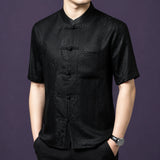 Front view of the black silk top, highlighting the geometric weave texture and the classic frog button placket.