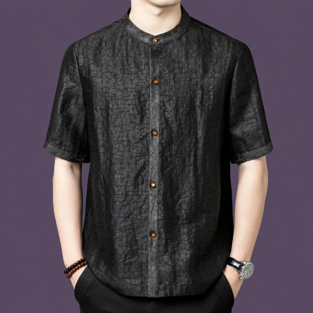 Men's black 100% mulberry silk short-sleeve shirt with a stand collar and contrast amber-colored front buttons, styled with black trousers.