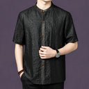 Front view of a black textured silk shirt with a clean button-down placket and a relaxed straight cut.