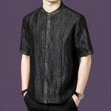 Men's black silk short-sleeve top featuring a unique cracked surface texture and a row of warm-toned buttons along the placket.