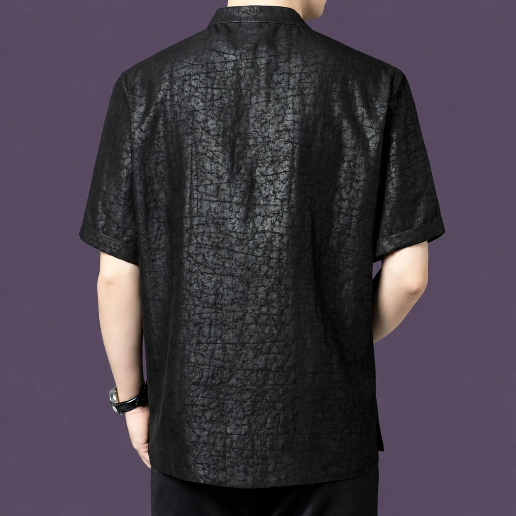 Back view of the men's black silk shirt, showing the straight, relaxed silhouette and the continued cracked texture across the back panel.