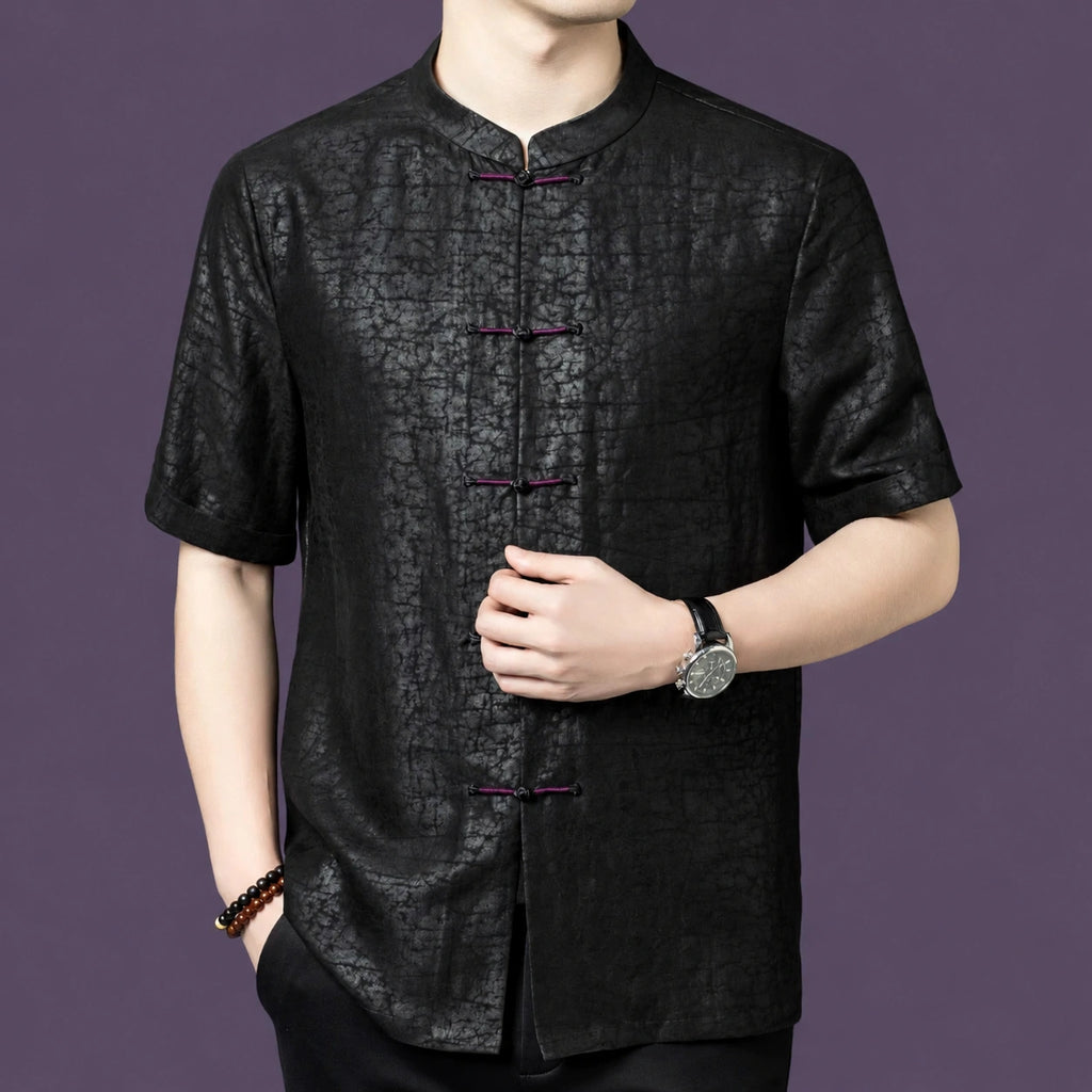Front view of a black silk short-sleeve shirt with a traditional Chinese stand collar and a row of color-contrast knot buttons.