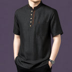 Close-up view of the black silk henley top, highlighting the four-button placket and single chest pocket.