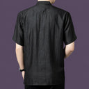 Back view of the black silk henley shirt, showcasing the relaxed drape and simple, clean back construction.