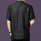 Back view of the black silk henley shirt, showcasing the relaxed drape and simple, clean back construction.